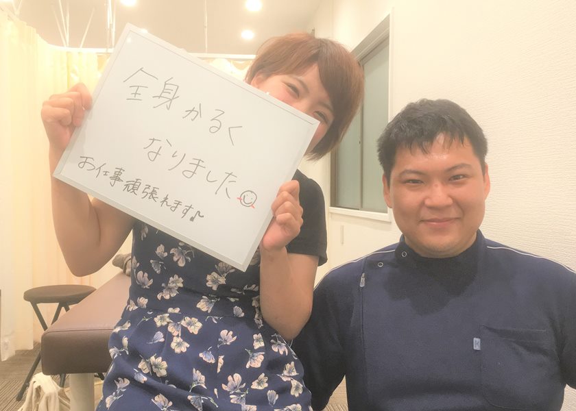 「全身かるくなりました」と書かれたボードを持つ女性と、院長のツーショット写真